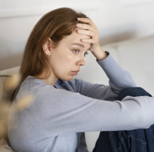 anxious-woman-sitting-couch-side-view